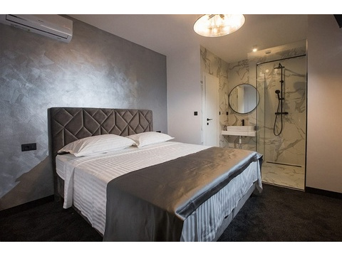 Schlafzimmer mit Doppelbett und offenem Bad en-suite