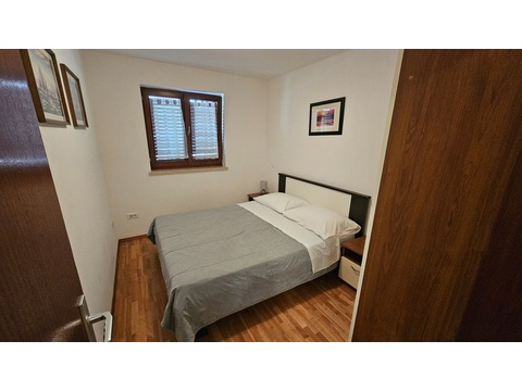 Zweites Schlafzimmer mit Doppelbett und Holzboden