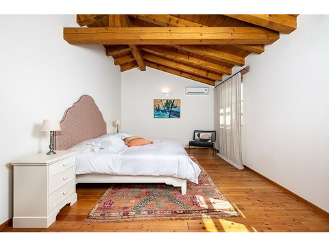Schlafzimmer mit Holzbalkendecke, Teppich und Klimaanlage