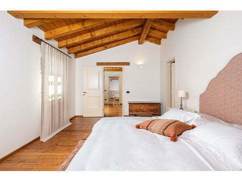 Schlafzimmer mit Vorhang und Holztruhe