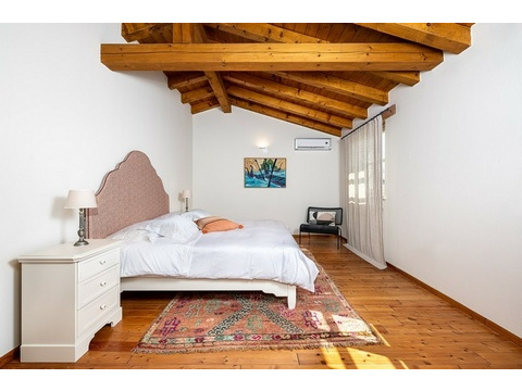 Schlafzimmer mit Kommode, Teppich und Gemälde