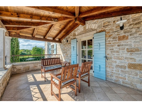 Terrasse mit Holzmöbeln und Blick ins Grüne