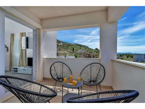 Terrasse mit Korbsesseln und Blick auf die Küste