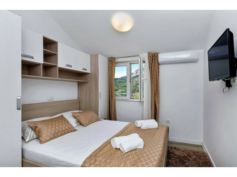 Schlafzimmer mit Doppelbett und Fernseher