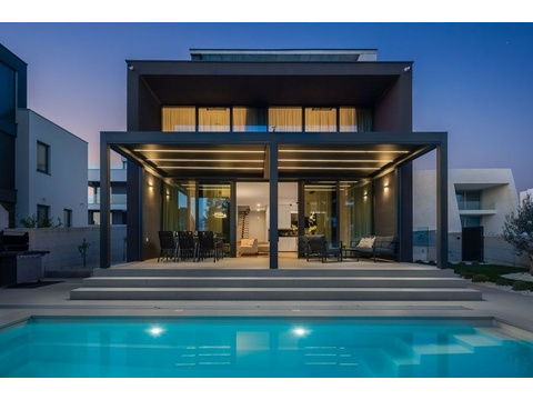 Villa am Abend mit beleuchtetem Pool