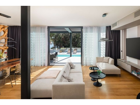 Wohnzimmer mit Sofa und Glasfront zum Pool