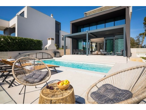 Poolbereich mit Hängesesseln und Grill