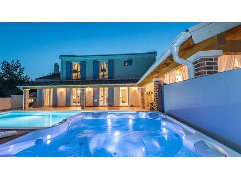 Beleuchteter Pool und Whirlpool am Abend