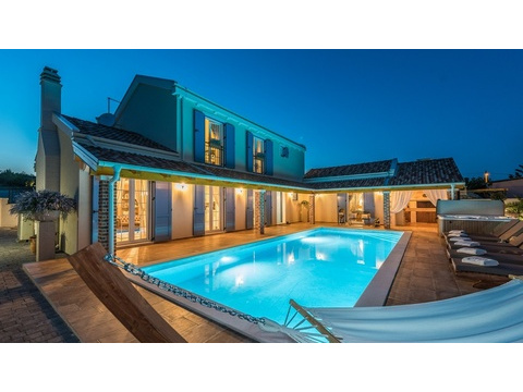 Villa am Abend mit Pool und Hängematte