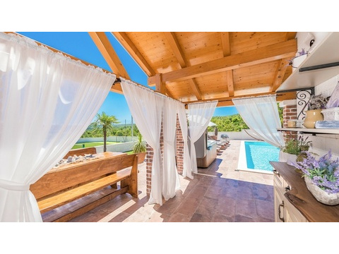 Terrasse mit Holzdach und Blick zum Pool