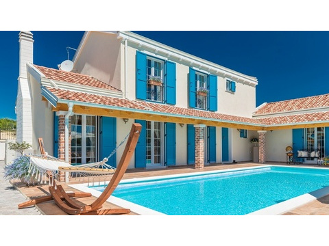 Villa mit blauen Fensterläden und Pool