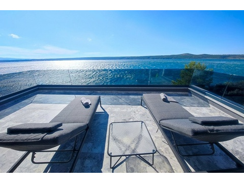 Terrasse mit Sonnenliegen über dem Meer