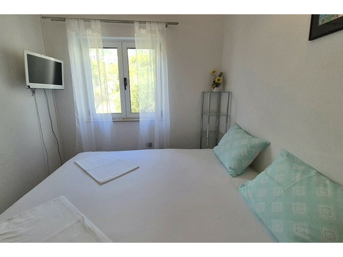 Schlafzimmer mit Fernseher an der Wand