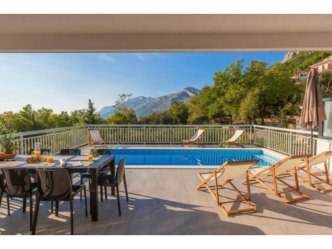 Pool mit Sonnenliegen und Blick auf das Gebirge