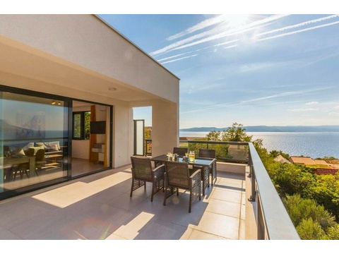 Terrasse mit Esstisch und Blick auf das Meer