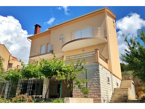 Haus mit rundem Balkon und Außentreppe