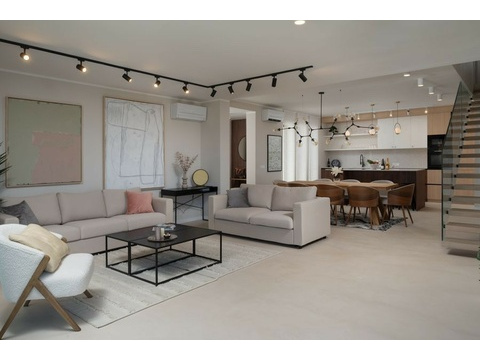 Wohnzimmer mit Sofas und offener Küche