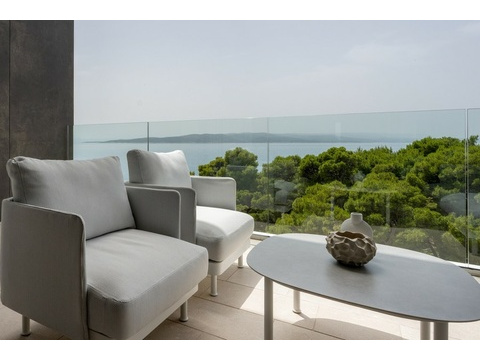 Terrasse mit Sesseln und Blick auf das Meer