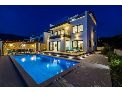 Villa am Abend mit beleuchtetem Pool