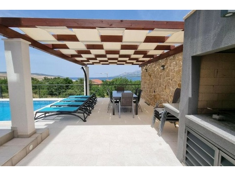 Terrasse mit Grill und Blick auf den Pool