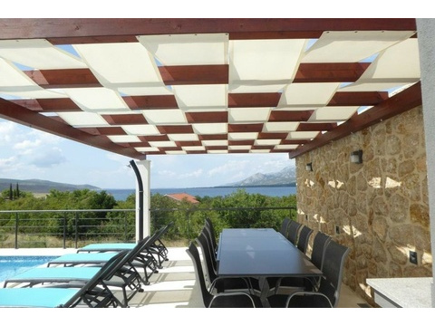 Überdachte Terrasse mit Esstisch und Meerblick
