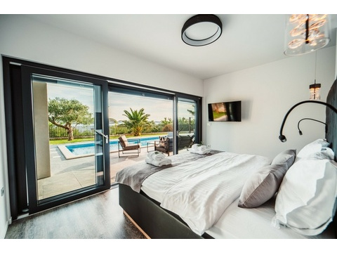 Schlafzimmer mit Glasfront zum Pool