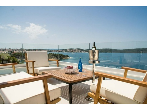 Terrasse mit Loungemöbeln und Blick auf die Bucht