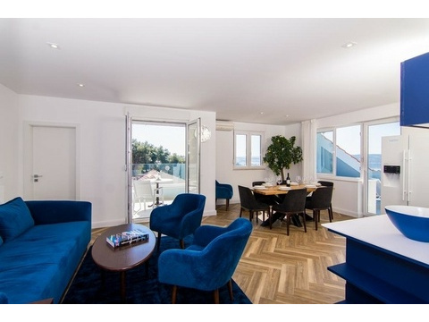 Wohnzimmer mit Sofaecke und Fenstern zum Meer