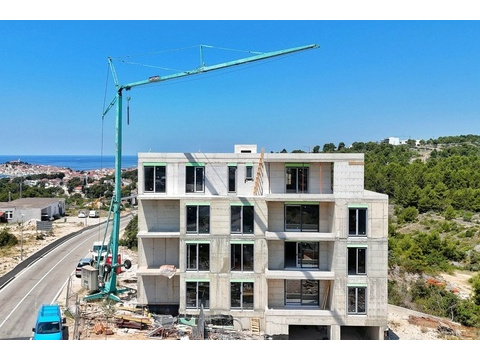 Baustelle mit Kran, links die Altstadt am Meer
