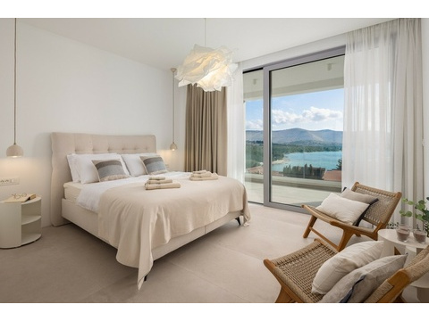Schlafzimmer mit Glasfront und Meerblick