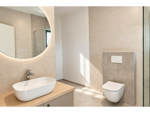 Badezimmer mit beleuchtetem Rundspiegel