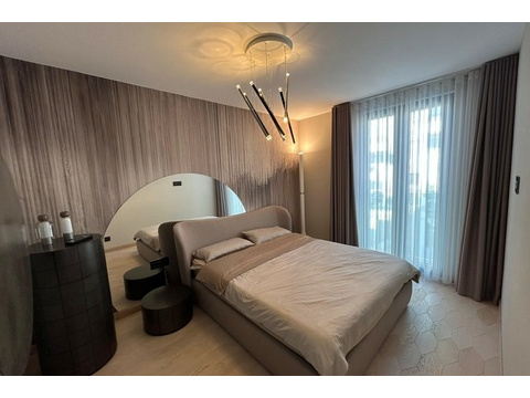 Schlafzimmer mit Polsterbett und Designerleuchte