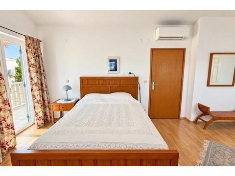 Schlafzimmer mit Holzbett und Klimaanlage