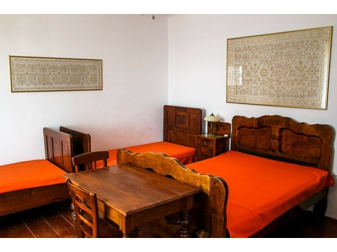 Schlafzimmer mit drei Betten und Holztisch
