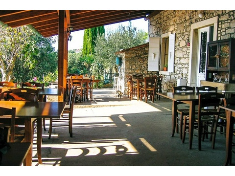 Überdachte Terrasse mit Tischen am Steinhaus