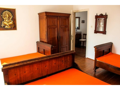 Zimmer mit Holzschrank und Blick in den Flur