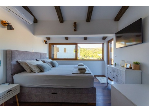 Schlafzimmer mit Fenster ins Grüne