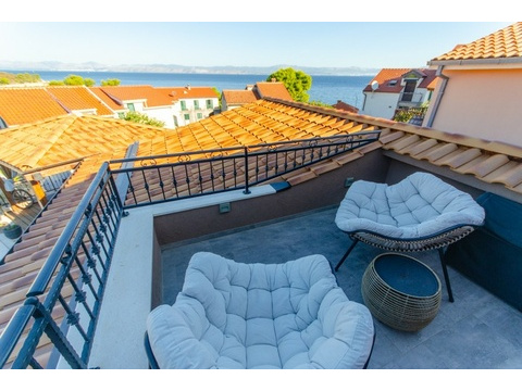 Terrasse mit Sesseln und Blick auf das Meer
