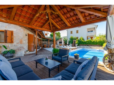 Überdachte Holzterrasse mit Sitzgruppe am Pool