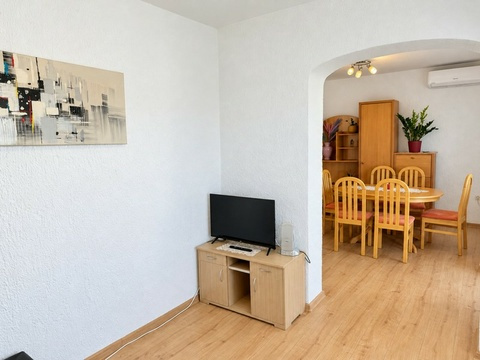 Wohnzimmer mit Fernseher und Esstisch
