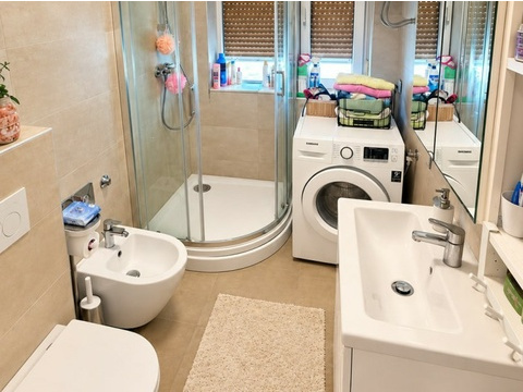 Badezimmer mit Dusche und Waschmaschine