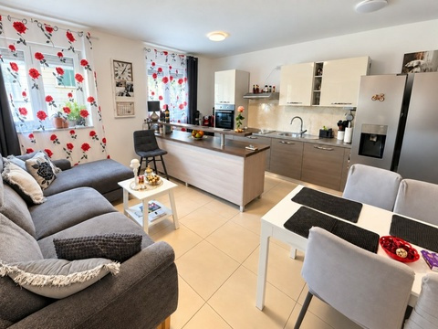 Wohnzimmer mit Sofa und offener Küche