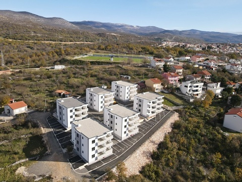 Wohnhäuser am Hang mit Bergen im Hintergrund