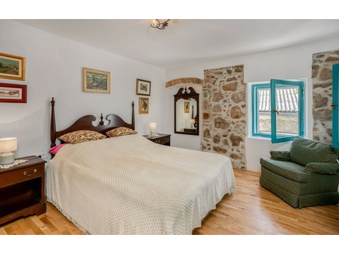 Schlafzimmer mit Holzbett und Sessel