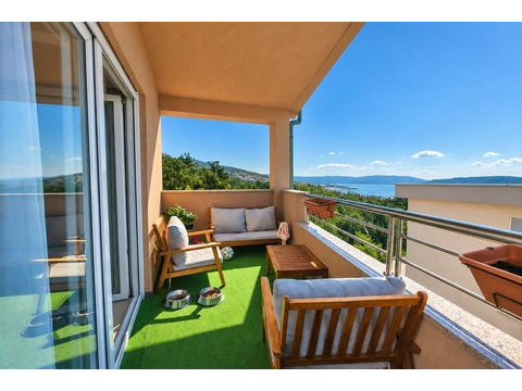 Balkon mit Holzmöbeln und Blick auf das Meer