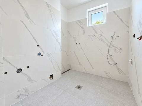 Badezimmer mit neuen Fliesen in Marmoroptik