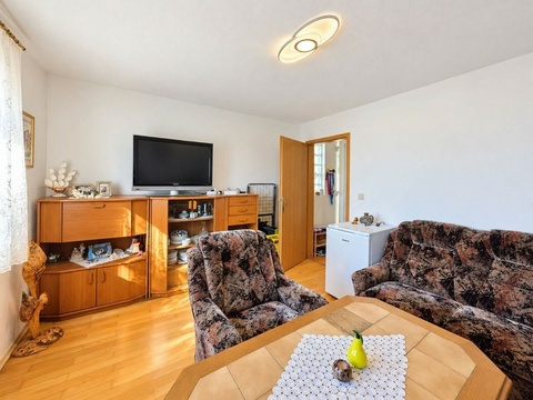 Wohnzimmer mit Fernseher und Holzboden