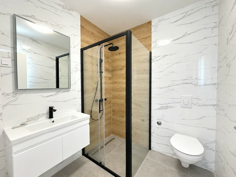 Badezimmer mit Regendusche und Holzoptik