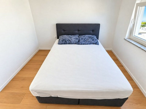 Schlafzimmer mit Doppelbett und Fenster
