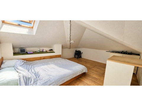 Dachzimmer mit Bett unter der Schräge